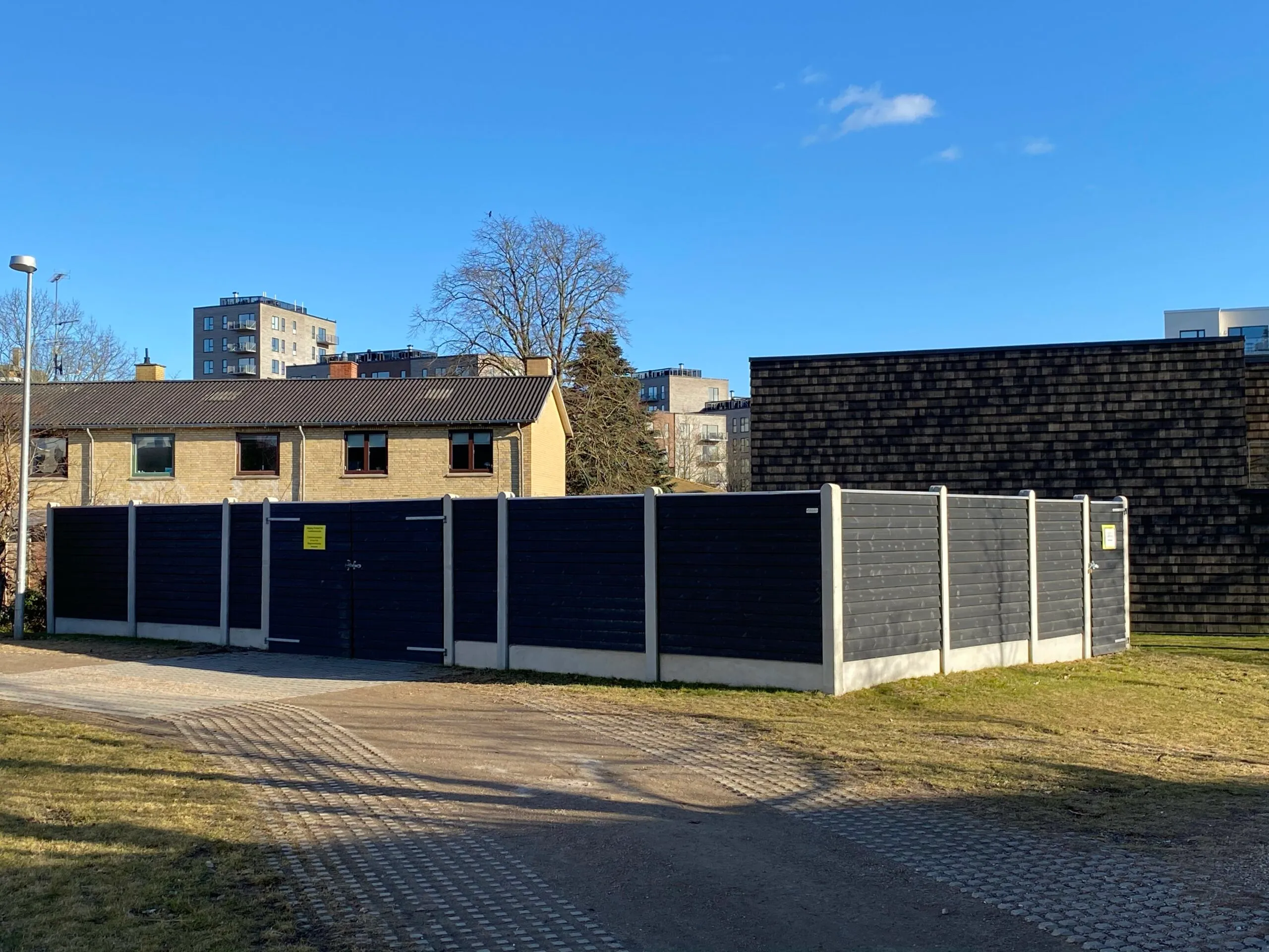 Storskraldsgården med sorte hegn og betonpiller i Bagsværdlund